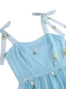 Close-up of daisy embroidery on light blue mesh dress with ribbon shoulder straps