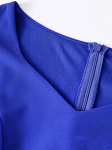 Detail of royal blue dress featuring a V-neckline and invisible back zipper closure