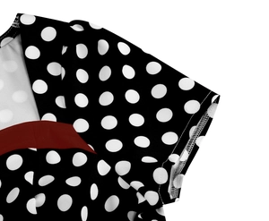 Detailed view of polka dot dress shoulder with red trim and premium stitching detail