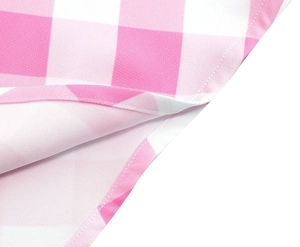 Détail du tissu vichy rose et blanc montrant des coutures précises et une texture en coton