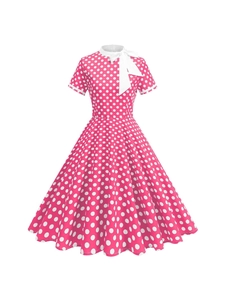 Robe rétro années 50 style Audrey Hepburn à pois roses, jupe trapèze et nœud blanc au col