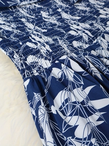Détail de la taille élastique froncée sur robe fleurie bleu marine au tissu sergé