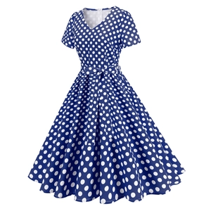 Dettaglio dell'abito blu navy a pois con scollo a V e fiocco decorativo in vita
