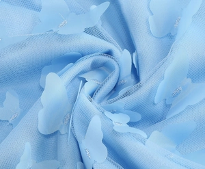 Primo piano del tessuto a rete blu con applicazioni di farfalle 3D e dettagli in filo argento