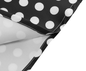 Detailed macro view showing black and white polka dot fabric texture and neat stitching