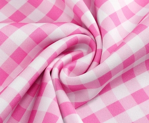 Close-up detail of pink and white gingham fabric with soft folds and woven texture