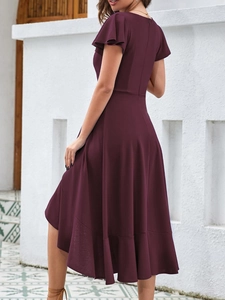 Detail of elegant burgundy evening dress featuring ruffled hem and side-back silhouette view
