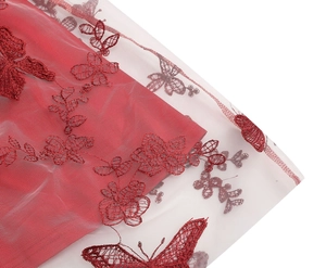 Detailed view of red lace mesh fabric featuring 3D butterfly and floral embroidery