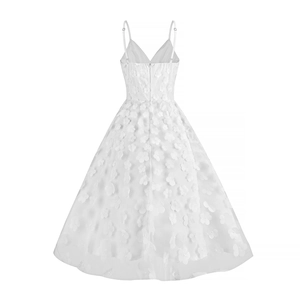 Detailed back view of white tulle dress featuring 3D floral appliques and deep V-neckline