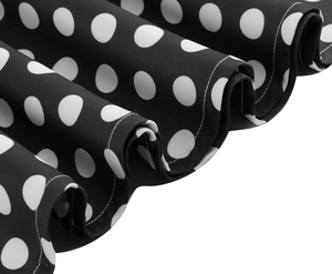 Detail of retro black polka dot fabric with elegant ruffled edges and soft texture