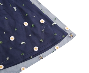 Detailed close-up of navy blue mesh dress with delicate daisy floral embroidery patterns
