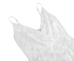 Close-up of elegant V-neckline with 3D floral appliques on white mesh summer dress