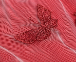 Detailed macro view of red mesh fabric featuring exquisite embroidered butterfly patterns