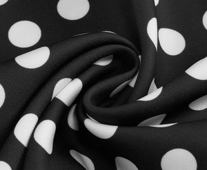 Macro shot of high-quality black fabric with white polka dot pattern and smooth texture