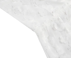 Detail of white mesh fabric with intricate 3D floral appliques for an elegant dress
