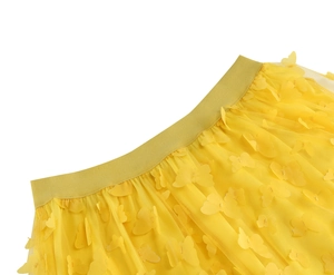 Dettaglio della gonna in tulle giallo con applicazioni di farfalle 3D e vita elastica