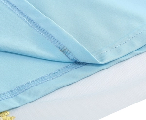 Detail shot of blue fabric seams with delicate yellow flower embroidery and mesh layers