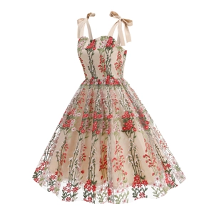 Detailed view of floral embroidery and bow shoulder straps on champagne mesh dress