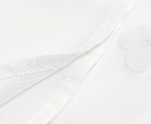 Detailed close-up of white mesh lace embroidery and high-quality stitching on dress