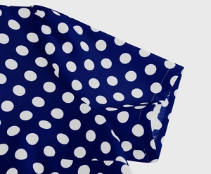 Dettaglio a pois bianchi su tessuto blu scuro con cuciture di qualità sulla manica
