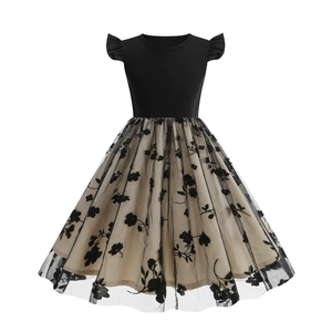 Close-up of girl's vintage dress with embroidered black floral mesh and layered tulle