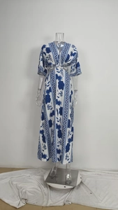 Detailed view of bohemian blue and white floral pattern on a deep V-neck maxi dress