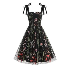 Close-up of floral embroidery on black mesh and shoulder ribbon bow detail on dress