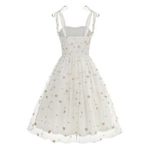 Detail of floral embroidery on a white mesh dress with smocked back and ribbon straps