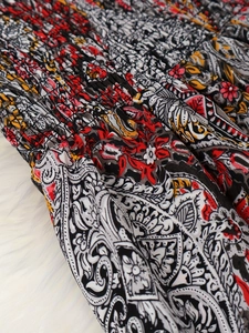 Détail d'une robe imprimée paisley bohème avec travail minutieux de smocks élastiques