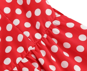 Détail macro de la robe rouge à pois montrant les coutures fines et le plissage du tissu