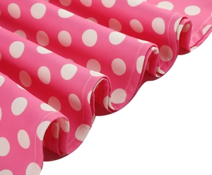 Dettaglio macro del tessuto rosa a pois bianchi con orlo ondulato e cuciture precise