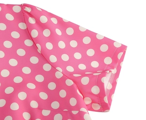 Dettaglio cucitura manica su abito rosa retrò con motivi a pois bianchi