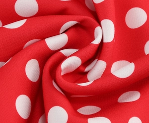 Gros plan sur la texture du tissu à pois rouge et blanc avec un drapé doux élégant