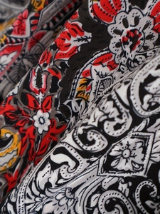 Macro d'un tissu à imprimé floral cachemire bohème avec motifs ethniques rouge et noir