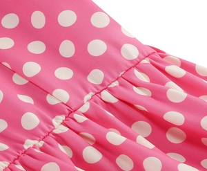 Dettaglio macro del tessuto rosa a pois bianchi con cuciture arricciate e pieghe rifinite