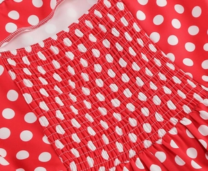Détail du tissu à pois rouges et blancs avec des finitions élastiques smockées