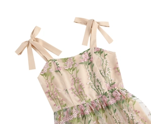 Close-up of fine floral embroidery and soft mesh fabric on a vintage party dress