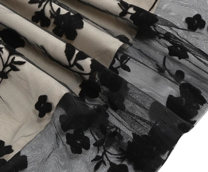 Detailed macro view of black velvet floral flocking on mesh fabric with soft lining