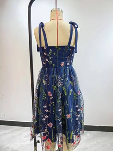 Detailed embroidery on navy tulle dress featuring adjustable bow shoulder straps