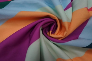 Detailed macro shot of wavy striped print fabric in purple orange and blue colors