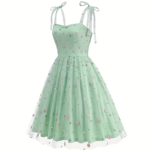 Close-up of light green floral mesh fabric with daisy embroidery and tie-shoulder straps