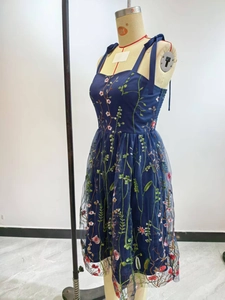 Detailed view of intricate floral embroidery on a navy tulle cocktail dress bodice