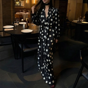 Close-up of V-neck polka dot dress with long ties and feather trim in a fine dining setting