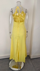 Detail showing the backless halter design with crisscross tie strings on a yellow maxi dress