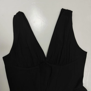 Detail of elegant black deep V-neck sleeveless dress with pleated bust and tie-up design