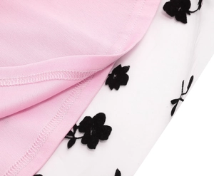 Detail of pink knit fabric stitched with white mesh featuring black floral patterns