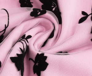 Close-up of pink mesh fabric with black floral patterns on the girls vintage long dress