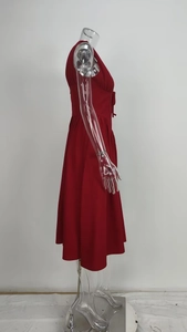 Detail of dark red V-neck dress featuring elegant pleats and a bow tie waist accent