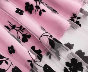 Detail of pink mesh fabric with black floral flocking on girl's vintage dress