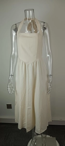 Elegant beige halter neck backless midi dress with bow detail shown on a mannequin